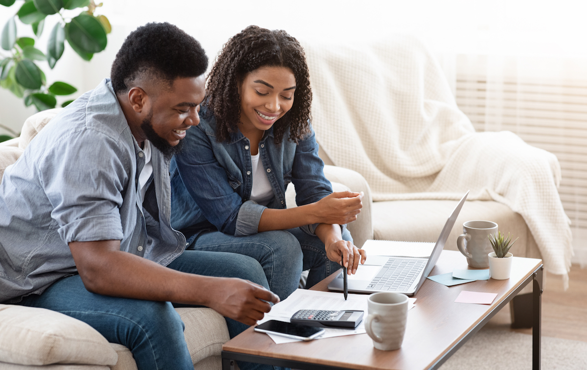 Household Budget. Smiling Black Couple Discussing Total Amount Of Their Spends At Home, Happy About Wise Planning