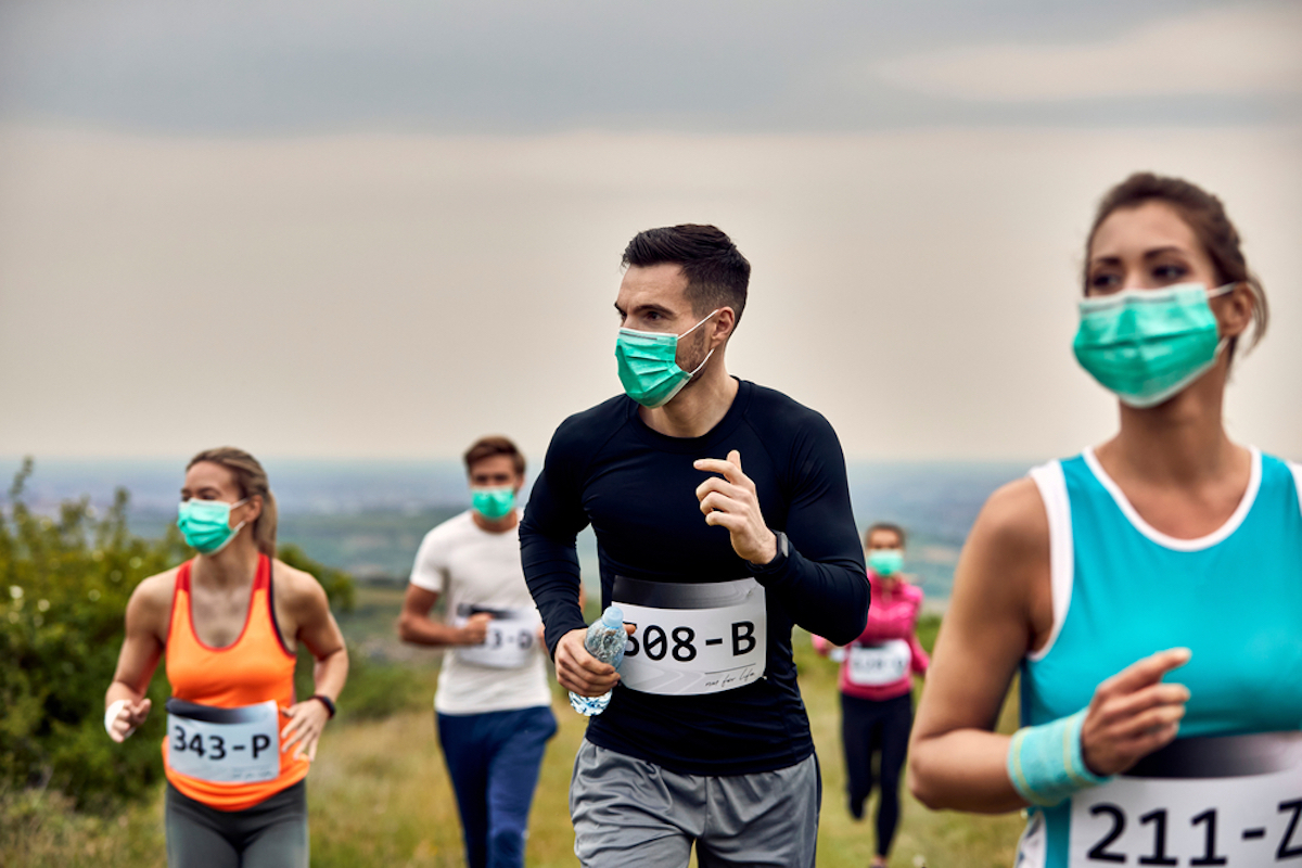 Group of runners wearing protective face masks while participating in a race during virus epidemic