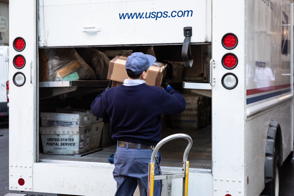 New York City, USA - February 4, 2019: USPS Postal worker load truck parked on street of midtown of New York City