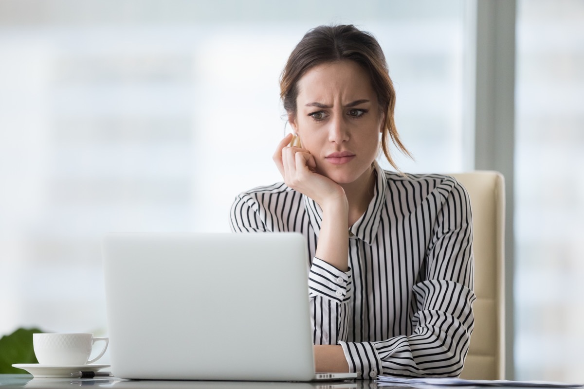 woman looking at laptop, worried look on face