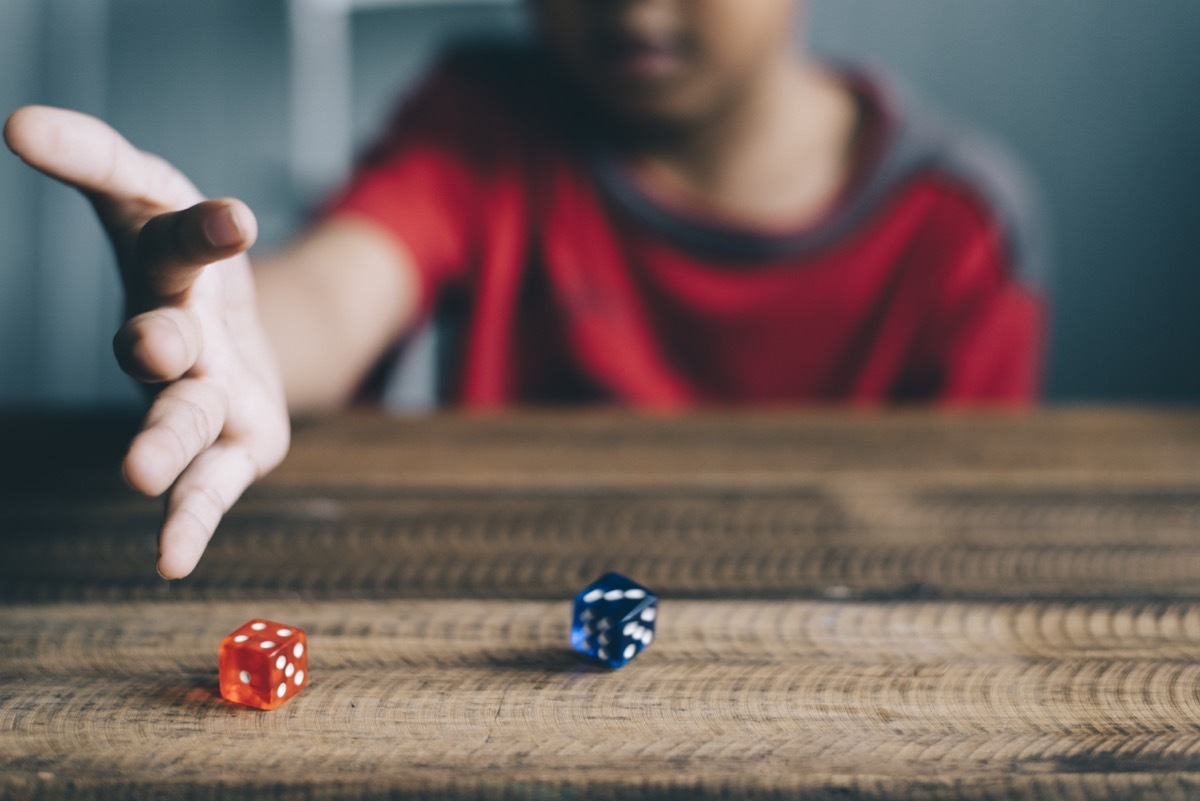 Kid rolling dice on table