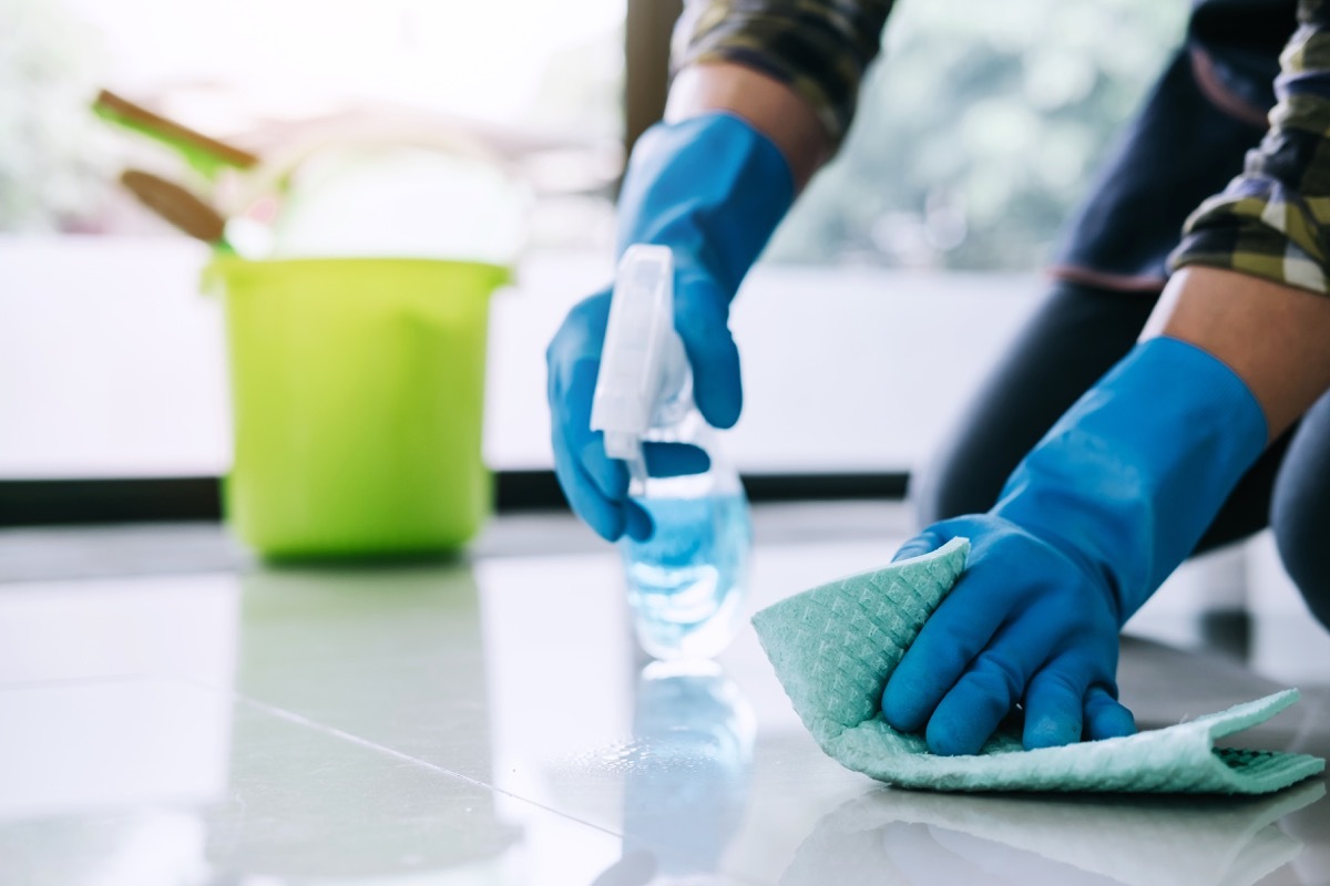 Man doing spring cleaning at home scrubbing floor