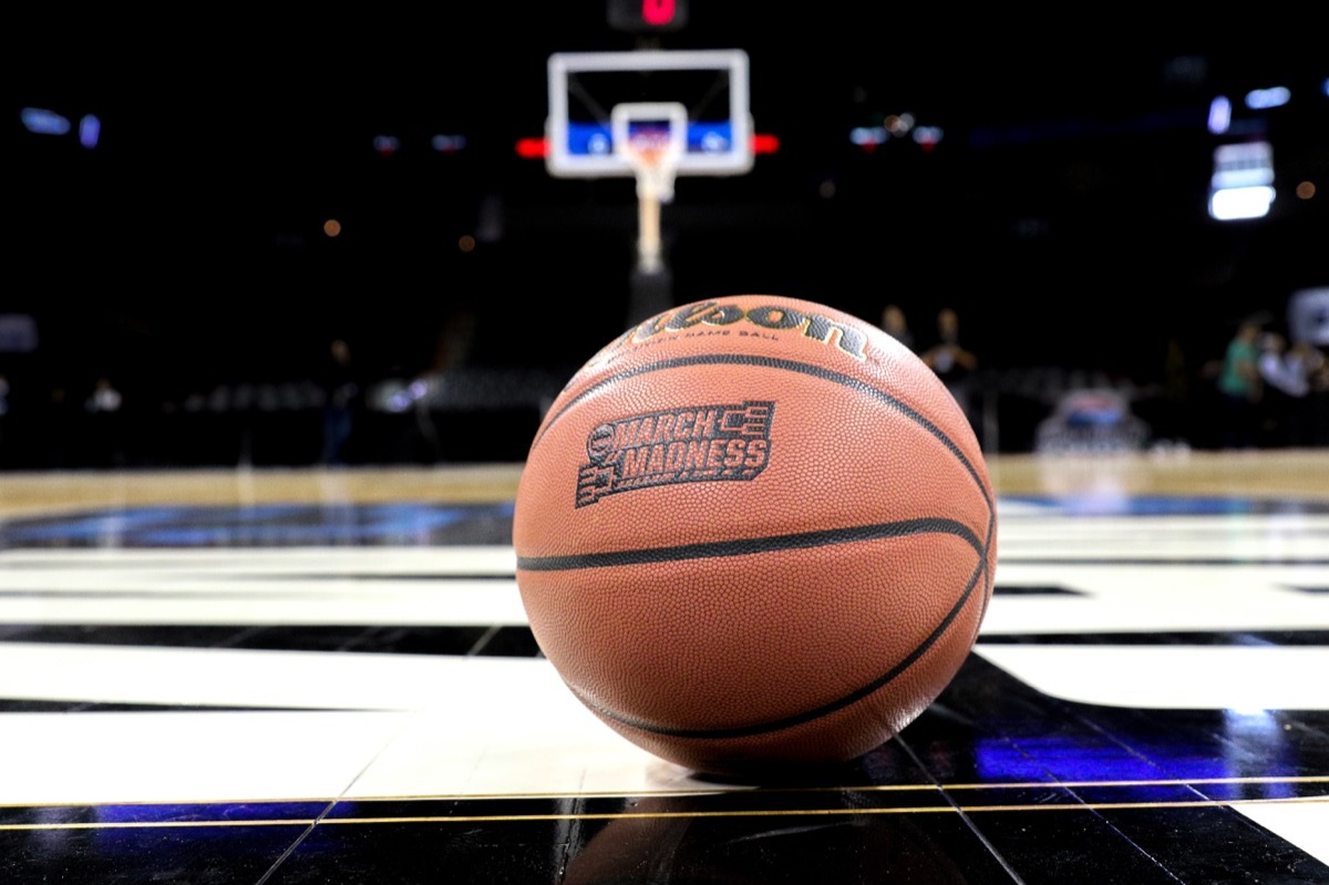 basketball sits on court with hoop in background