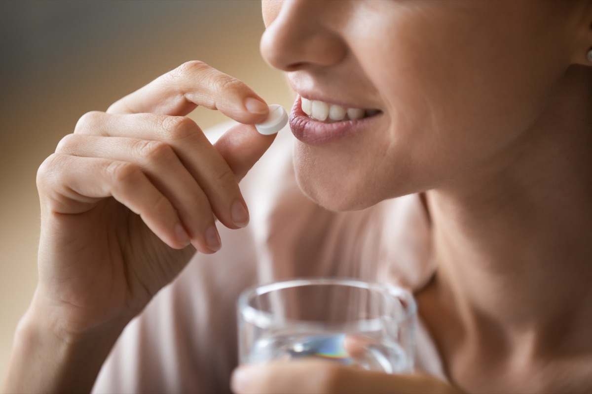 Woman Taking a Tablet with Water