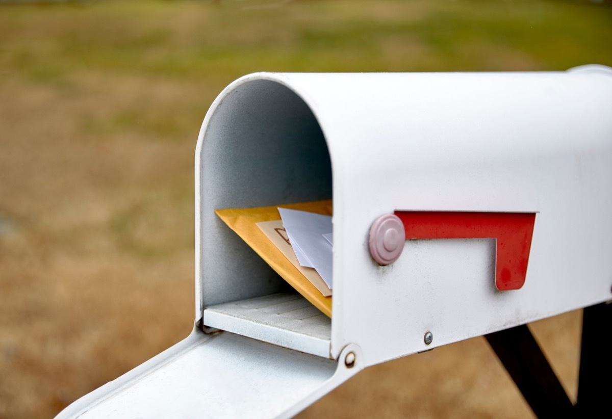 Close up of a mailbox opened with the contents of the mailbox showing with shallow depth of field