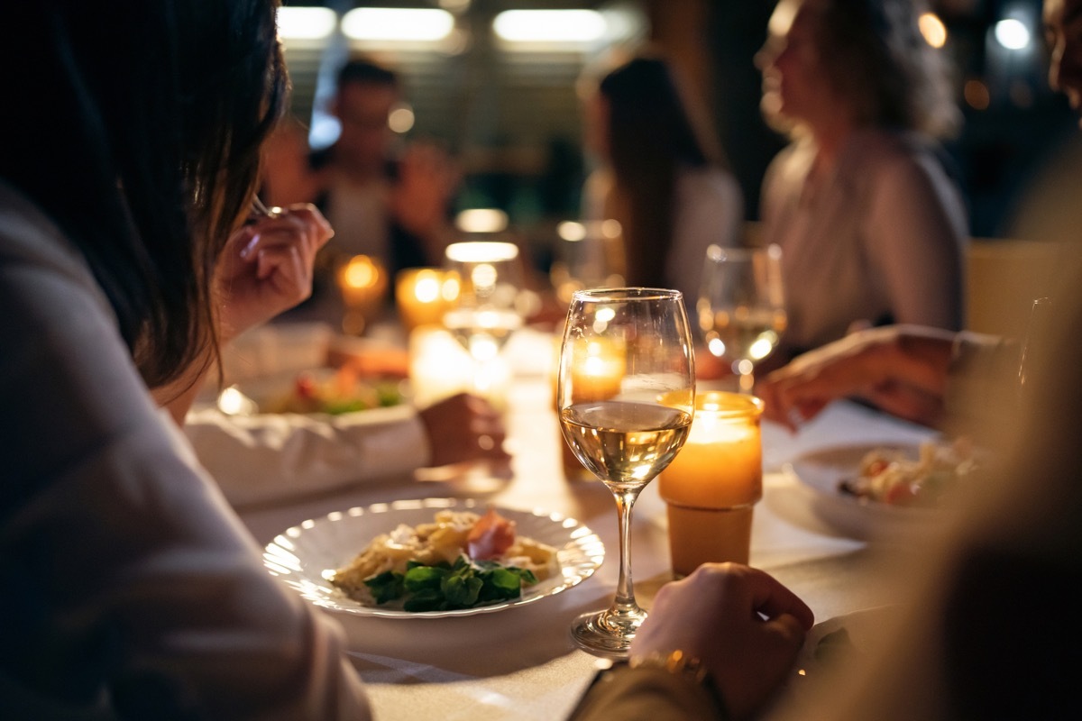 Group of female and male friends, having the dinner at the restaurant balcony