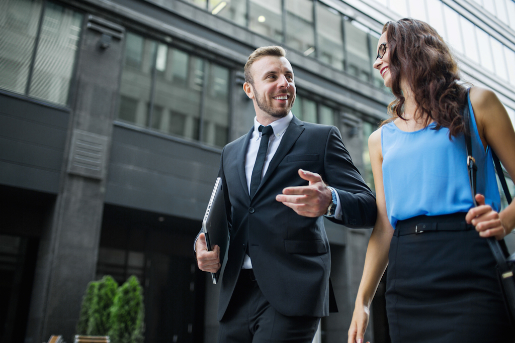 a man and a woman in business suits walk and talk