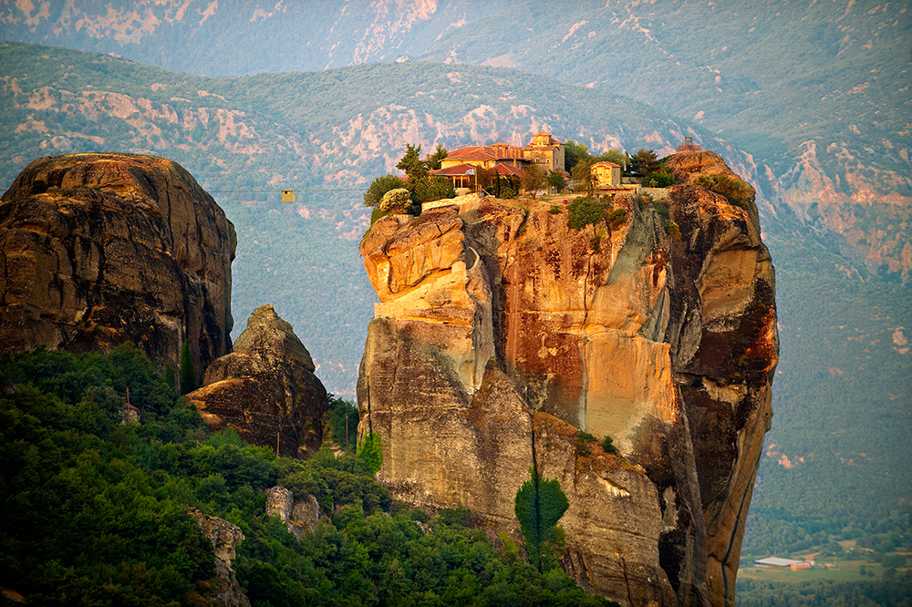 overview of the roussanou monastery on top of a giant rock formation