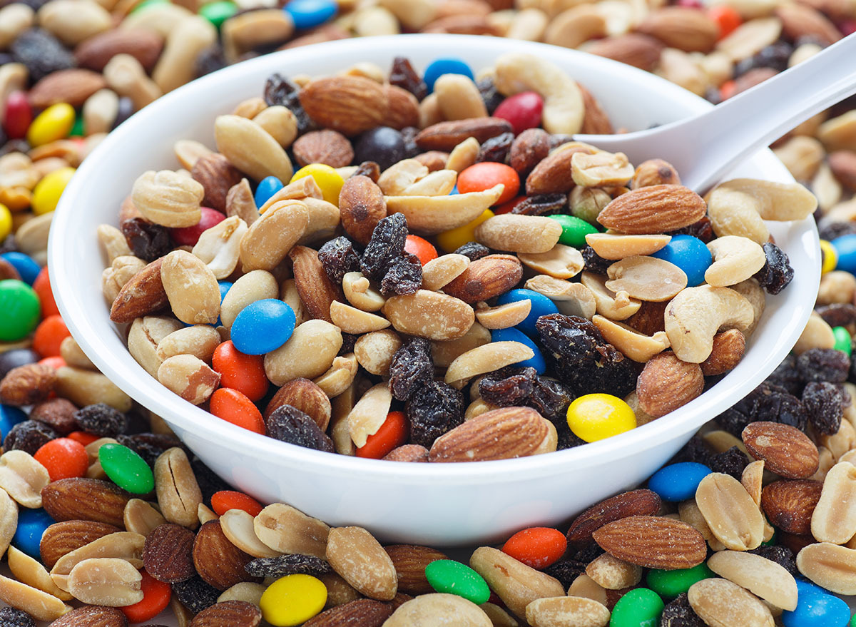 Colorful trail mix in a white bowl with spoon