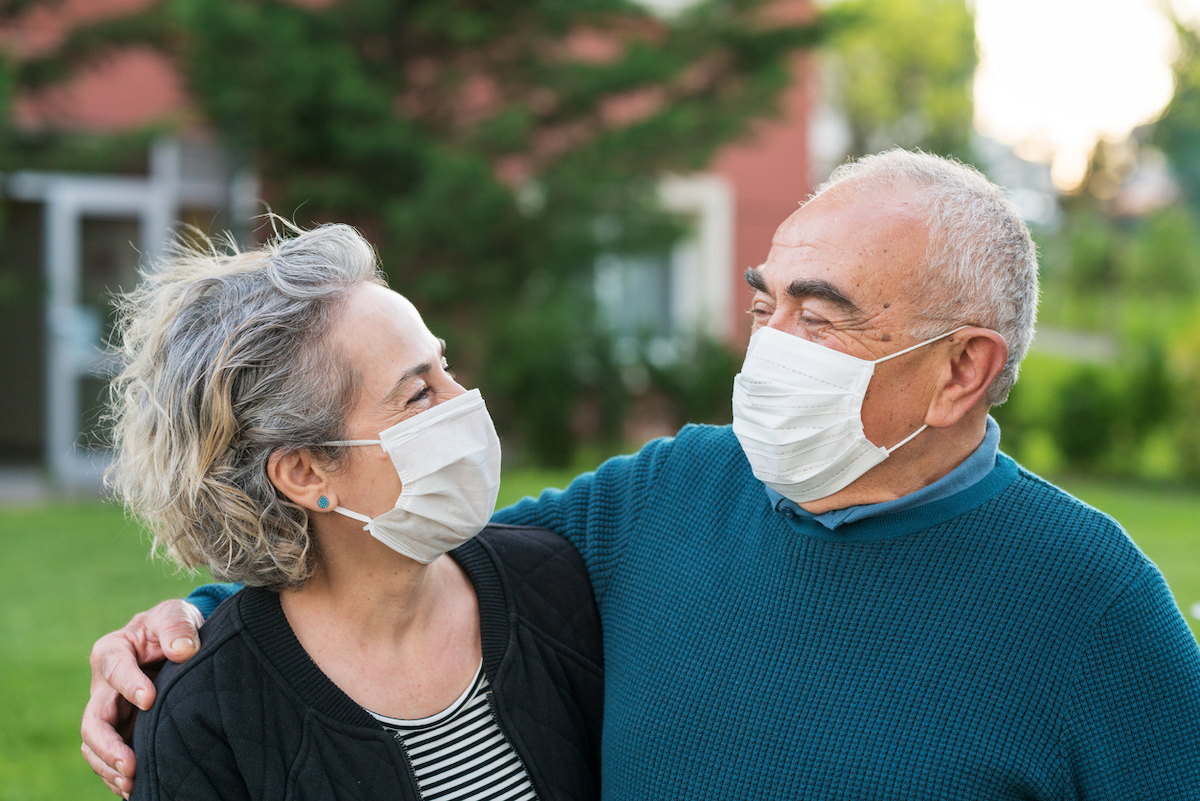 senior couple Couple wear surgical masks and smiling at each other