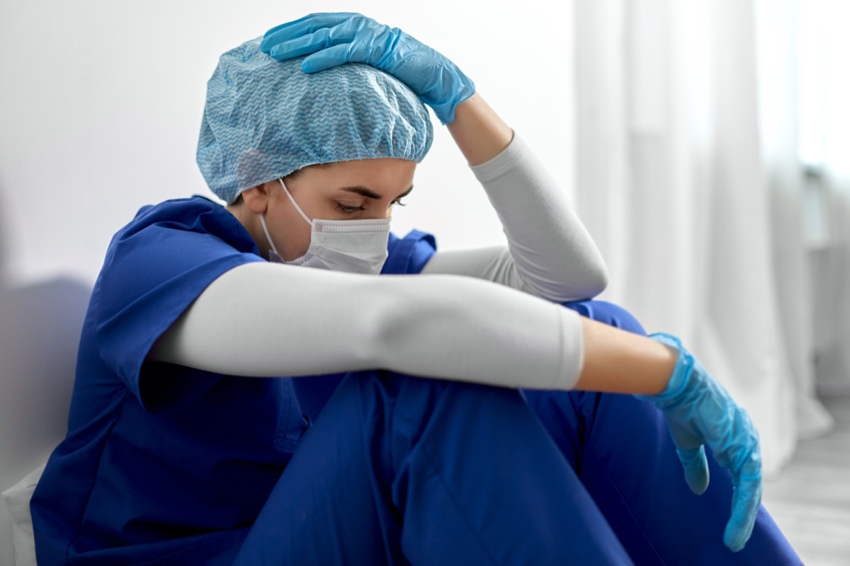 sad young female doctor or nurse wearing face protective mask for protection