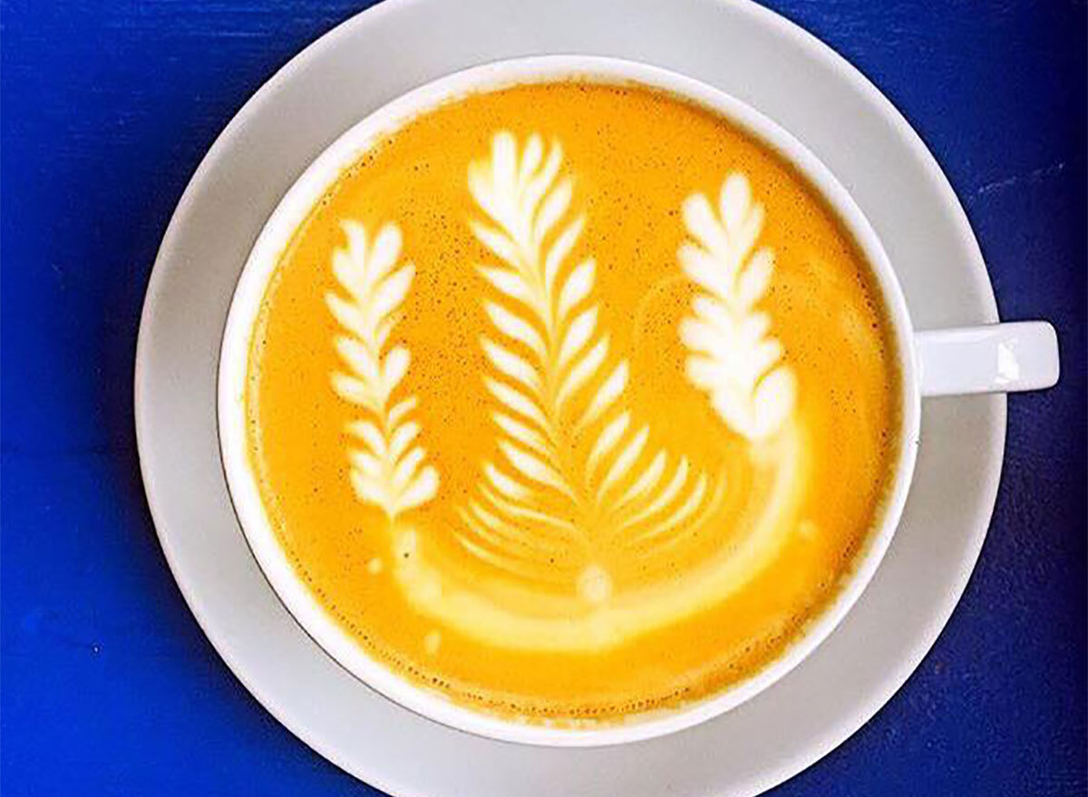 latte in mug with latte art on blue background