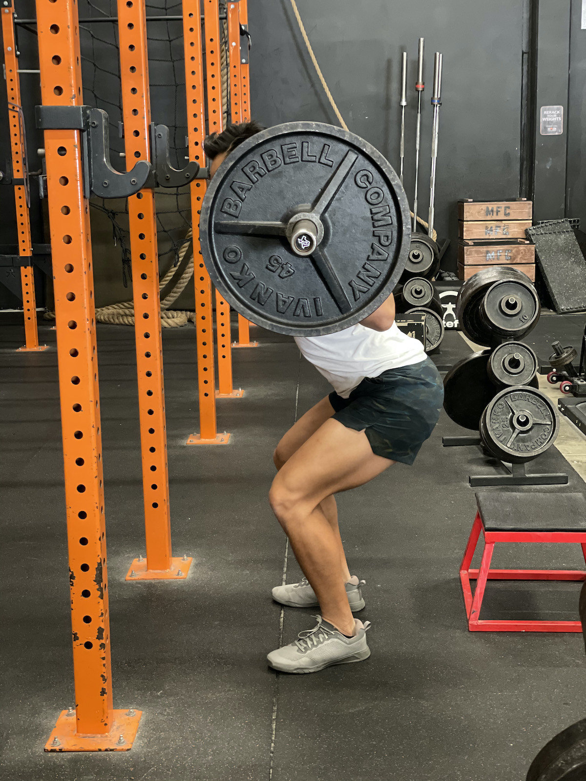 tim liu doing a squat with an extra quarter rep