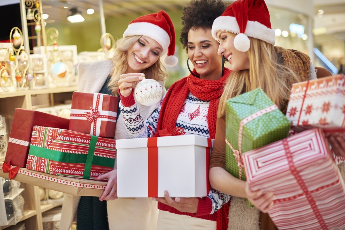 woman with presents looking at christmas decorations