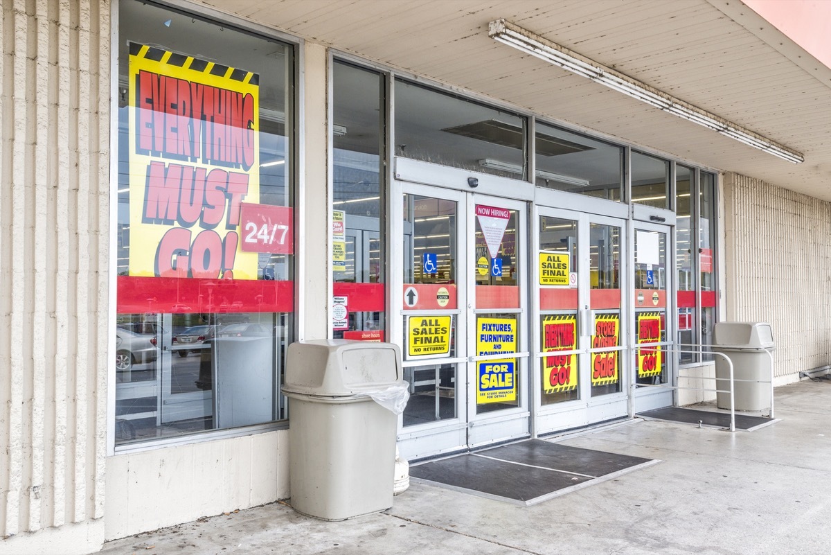 Horizontal shot of the front of an old run-down department store going out of business.