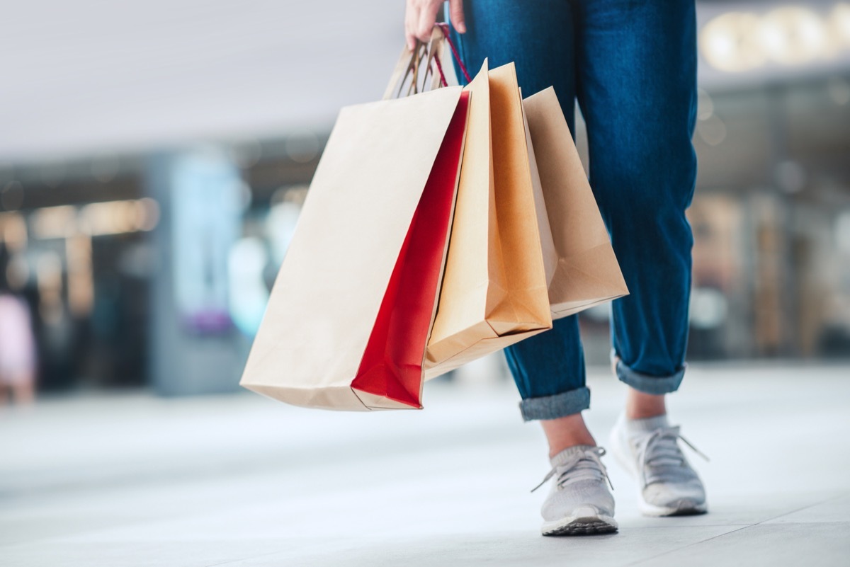 Woman holding sale shopping bags. Consumerism, shopping, lifestyle concept