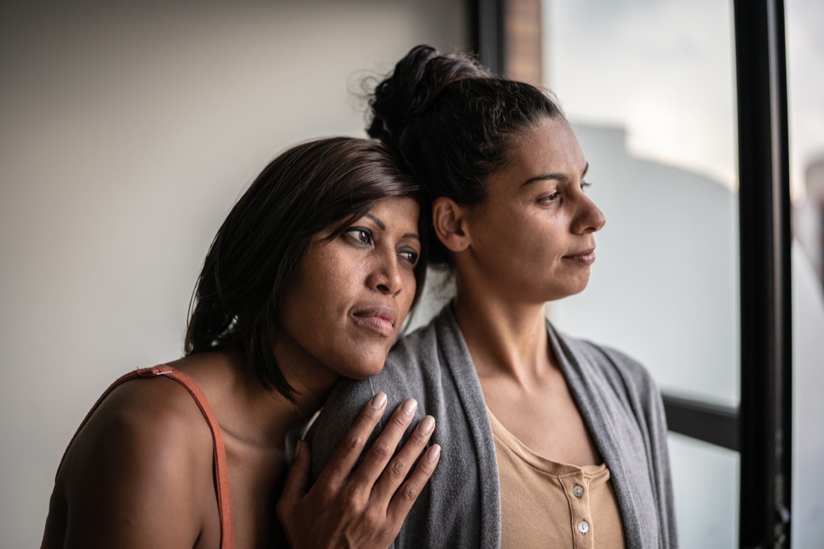 Contemplative lesbian couple at home