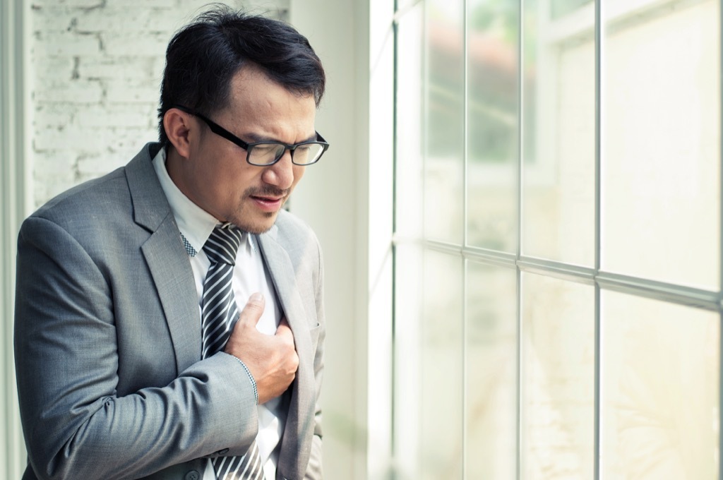 man clutching chest in pain 