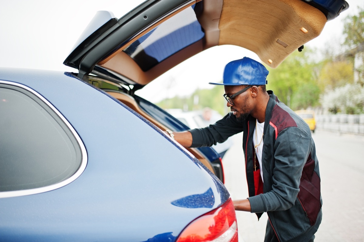 man putting emergency items in his car trunk, safety tips