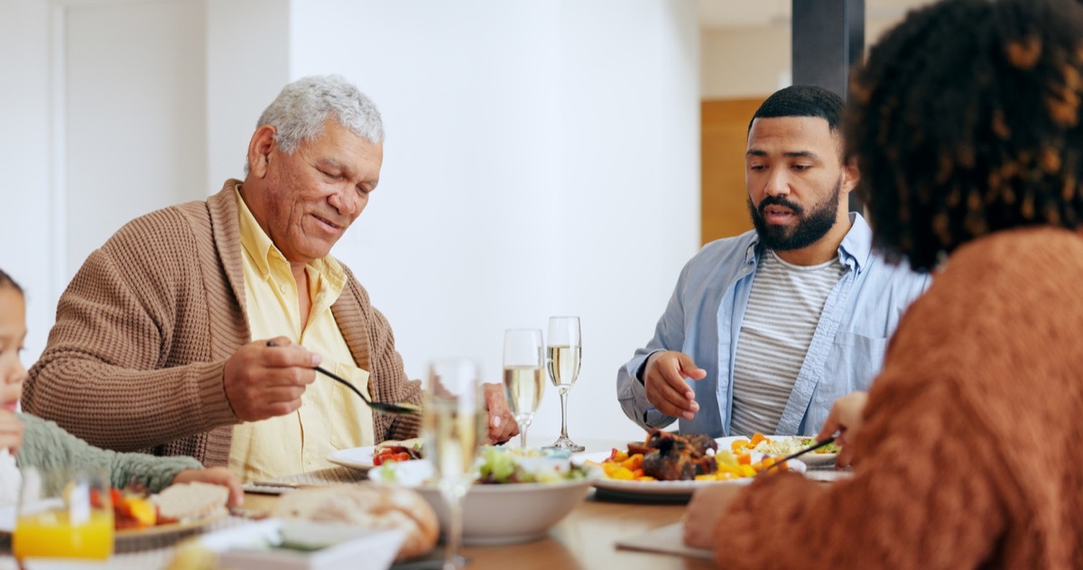 Love, thanksgiving and a family at the dinner table of their home together for eating a celebration meal. Food, holidays and a group of people in an apartment for festive health, diet or nutrition