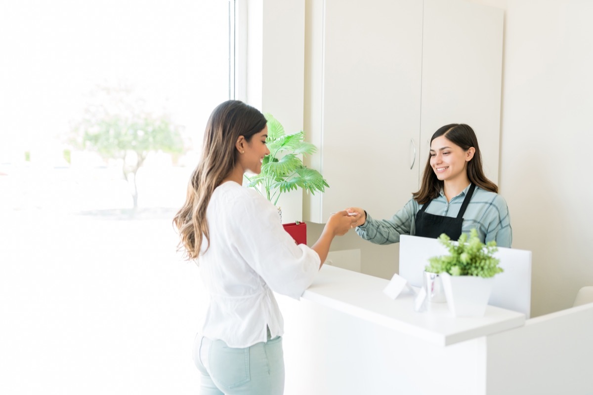 Client handing card at salon