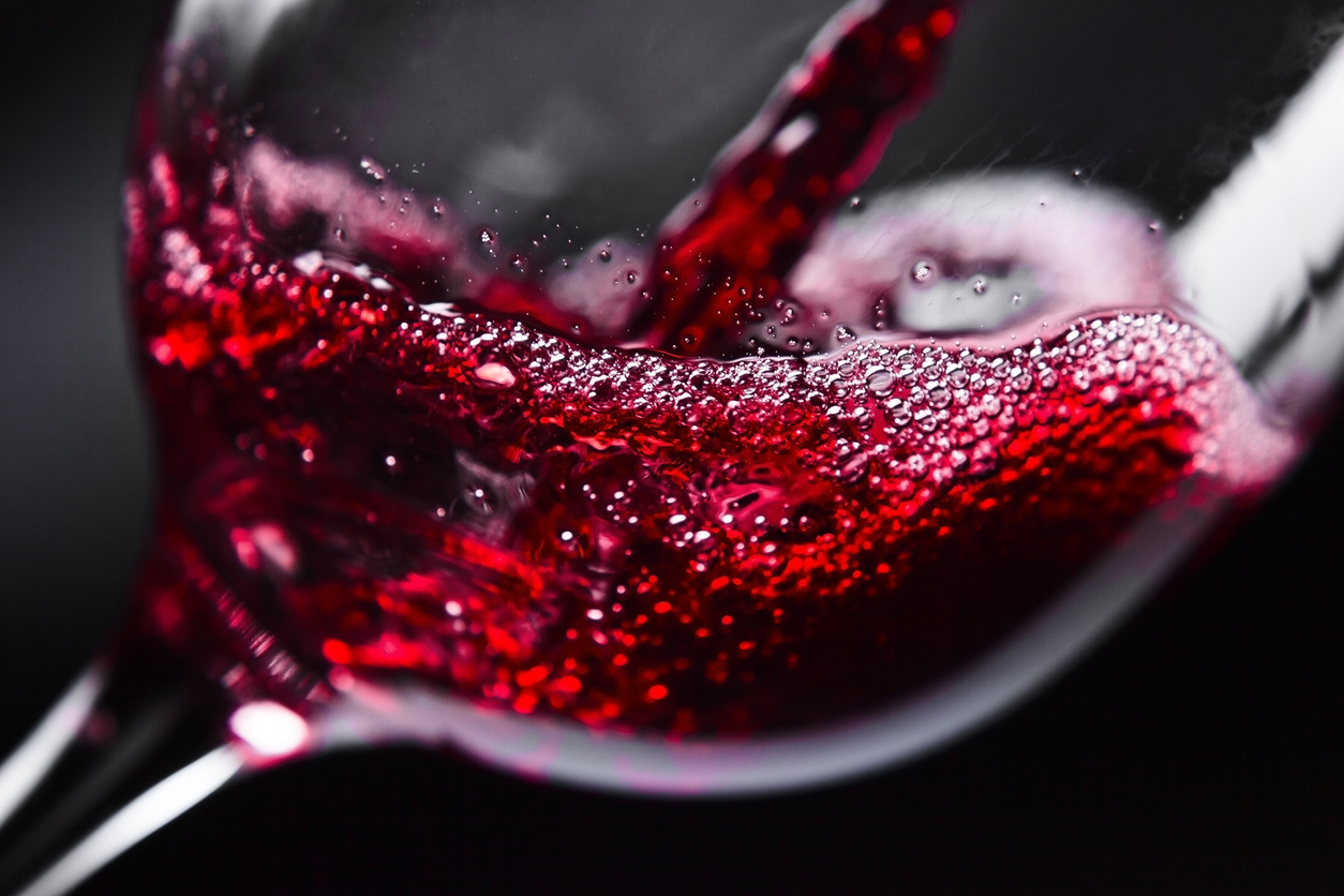 Red wine being poured into a glass.