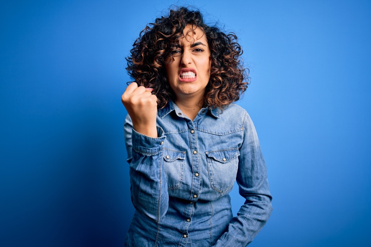 woman responding angrily with her fist in the air after receiving the best insults