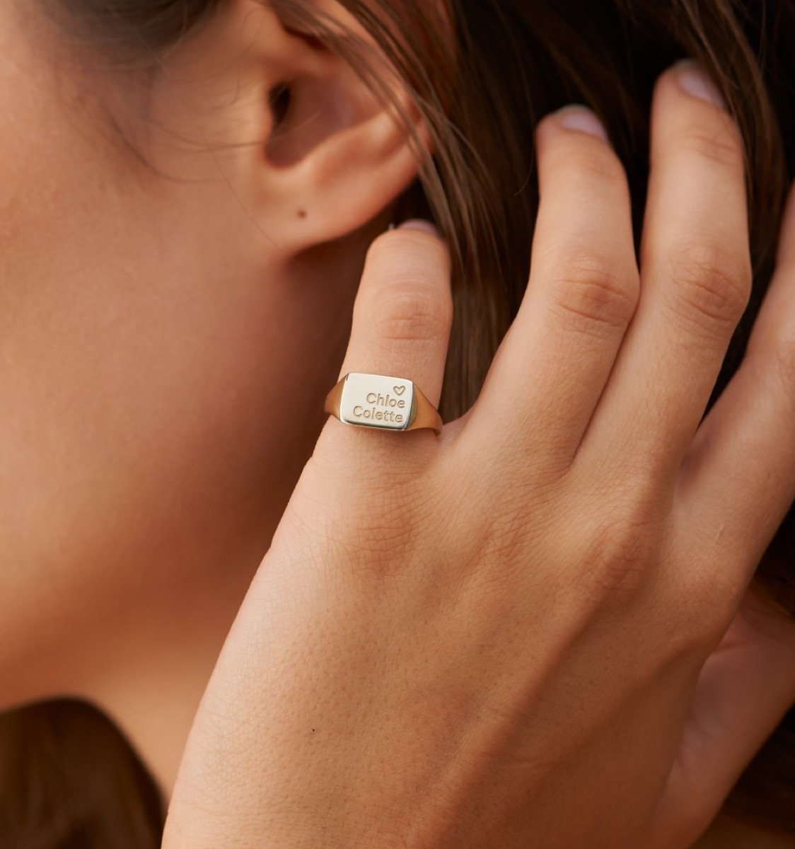 Woman wearing engraved square signet ring