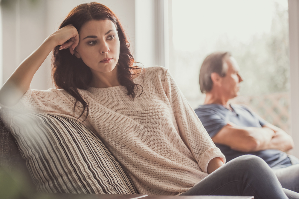 Unhappy couple on couch fighting or having problems