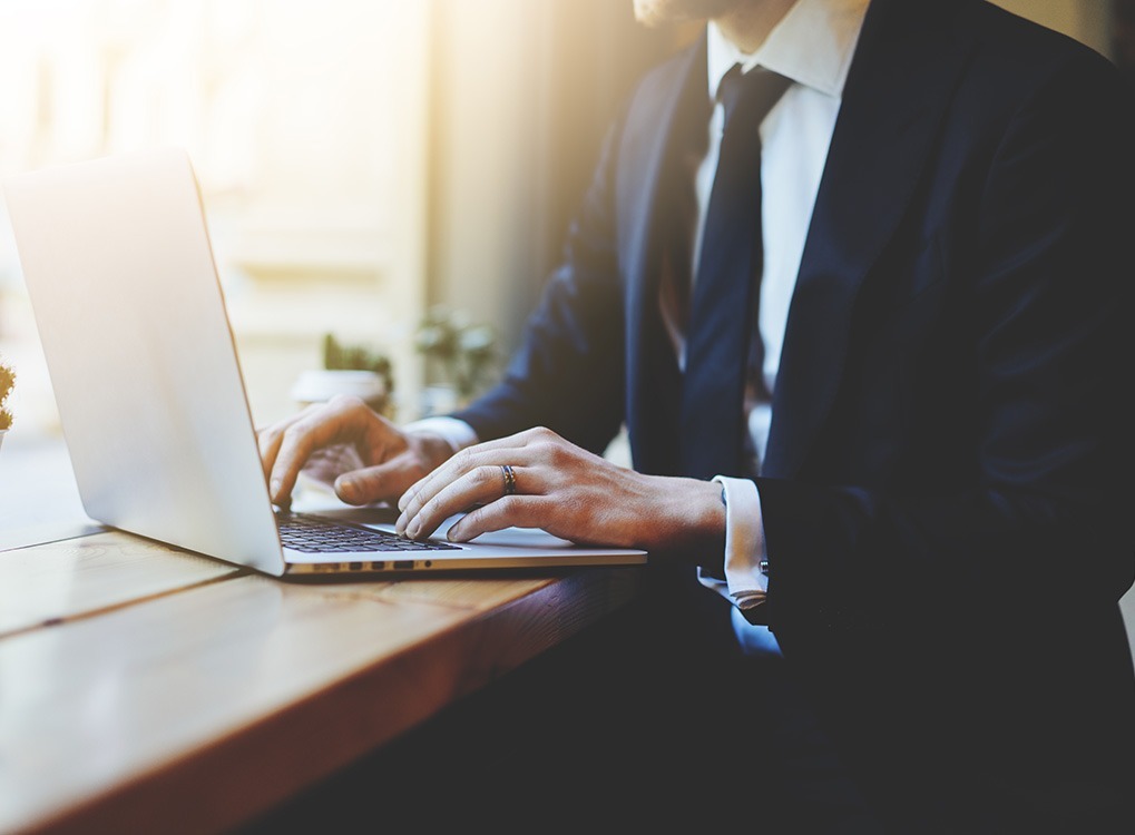 man wearing a suit sitting at a computer