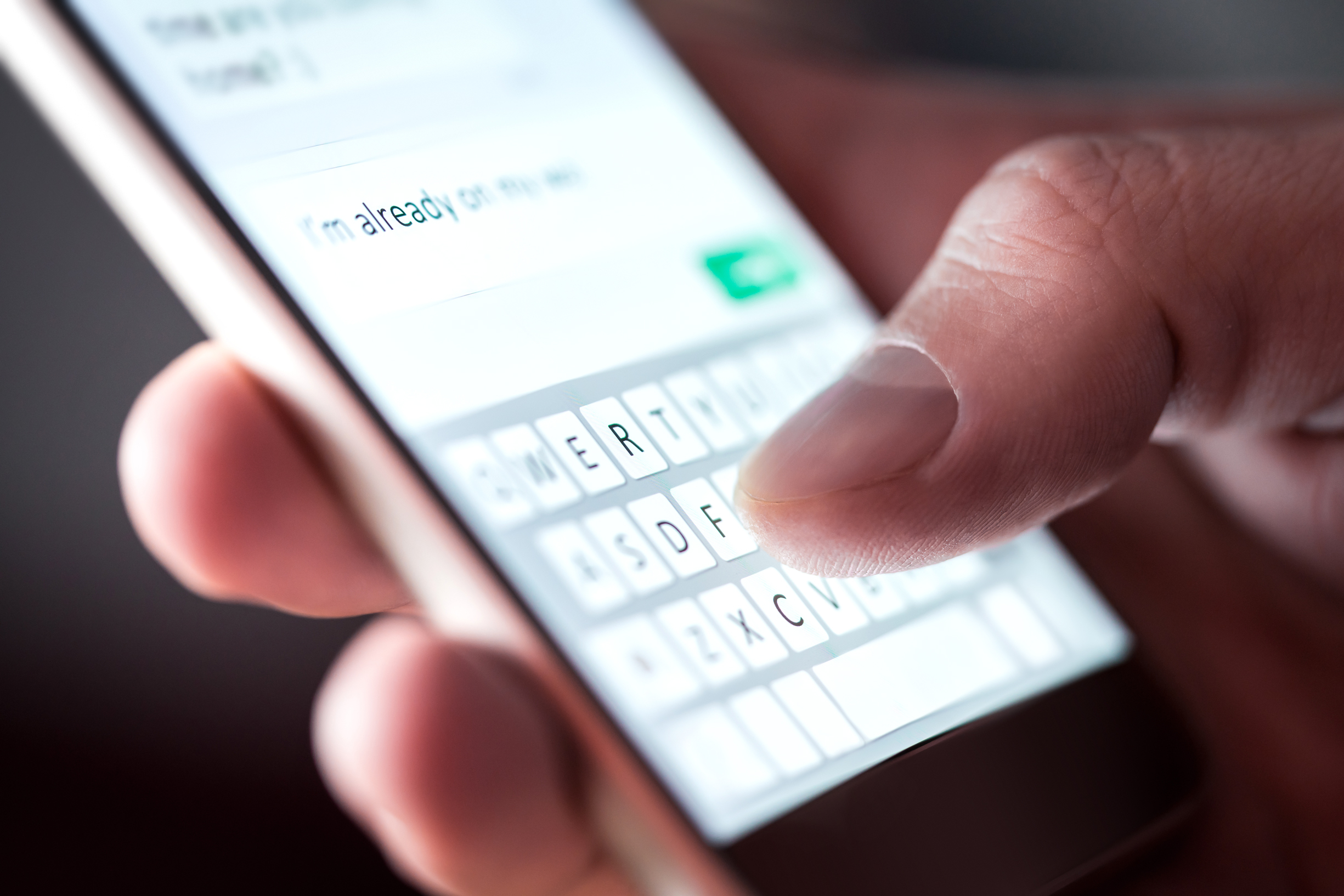 close-up of a man sending a text message on his phone