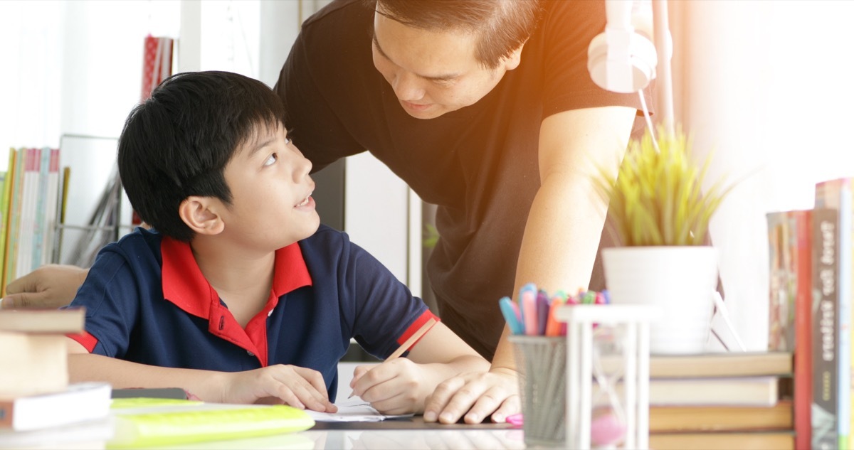 asian father and son journaling together