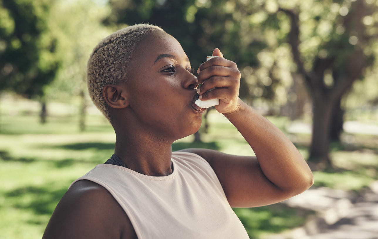 Woman using an asthma inhaler.