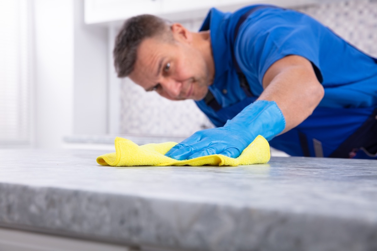 Man cleaning kitchen counter