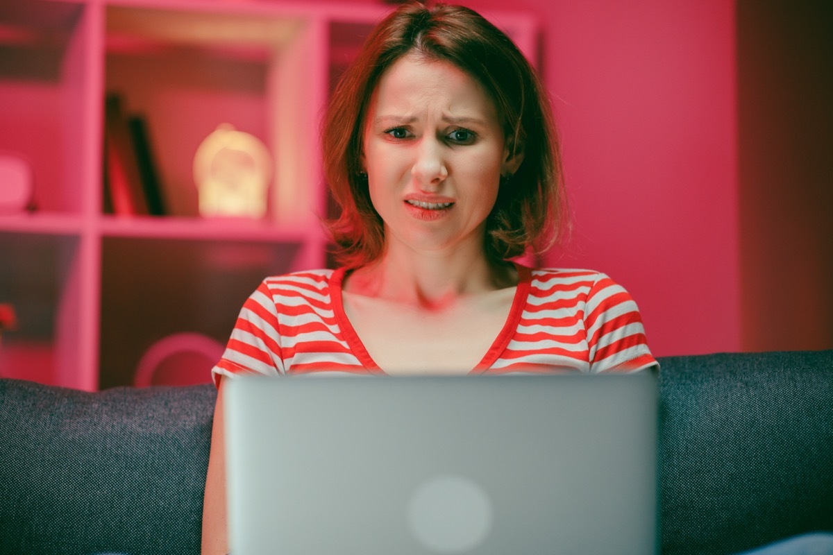 Shocked stressed young woman looking at laptop screen feeling bad surprise,