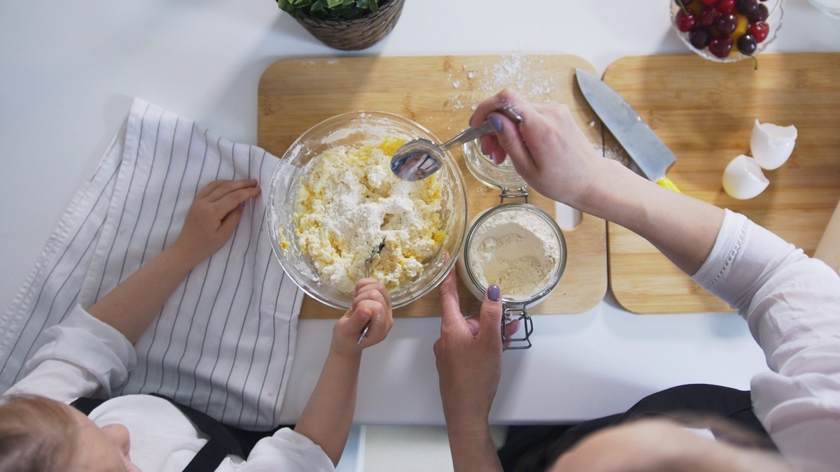 Mother and daughter preparing dough for cottage cheese pancakes