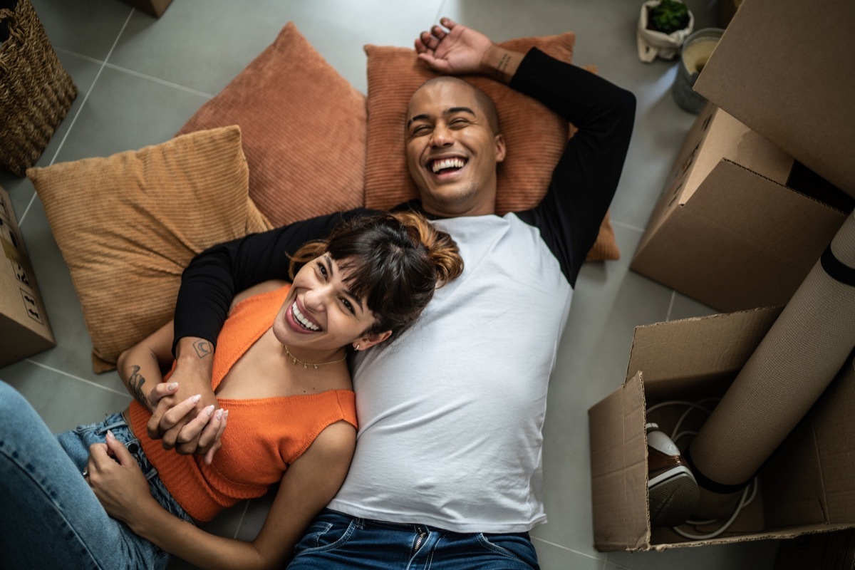 Happy young couple lying on the floor at new home