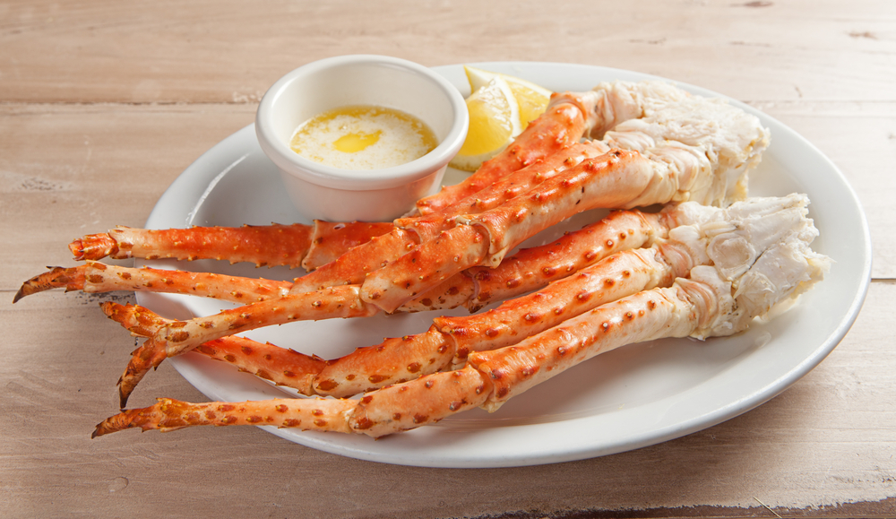 Cooked snow crab legs on a plate with a side of butter