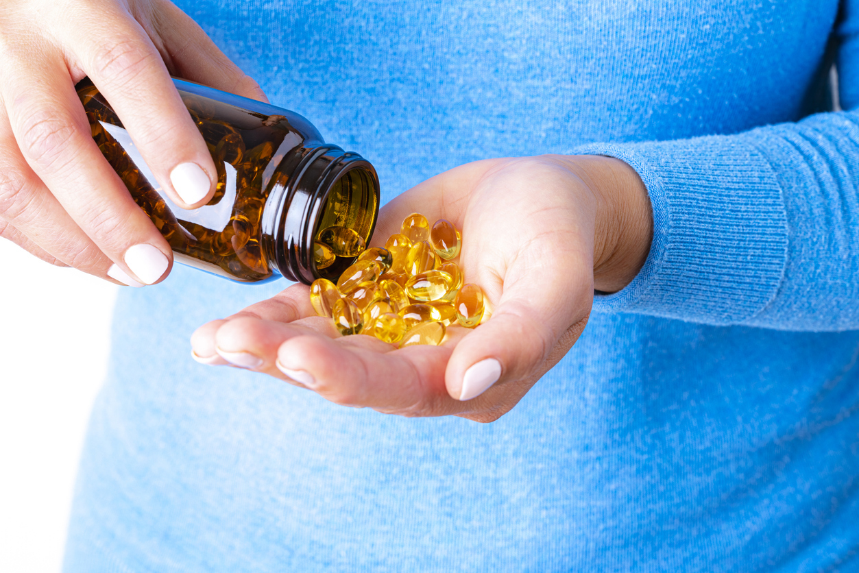 Capsules in bottle being poured into hand.