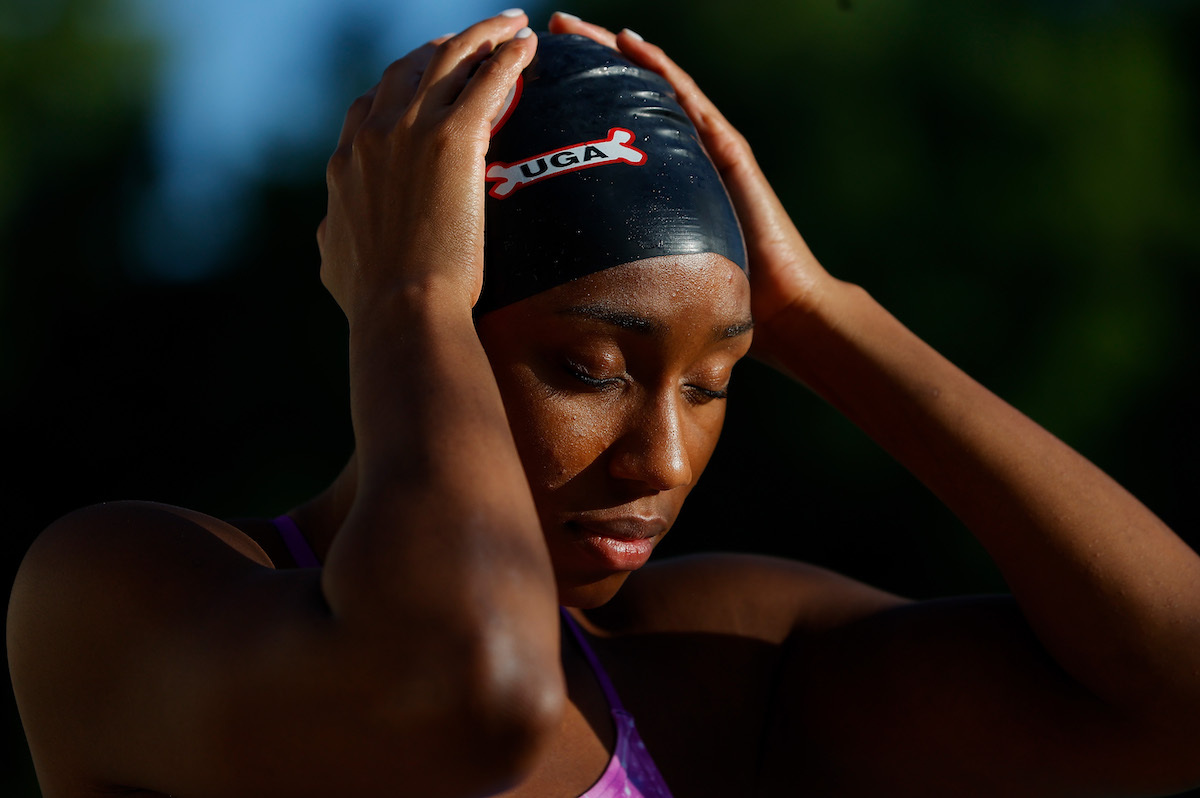 Natalie Hinds puts on her swim cap to train in a residential pool on May 15, 2020 in Athens, Georgia. Due to the COVID-19 pandemic, many elite athletes have been forced to adjust training locations and regimens.