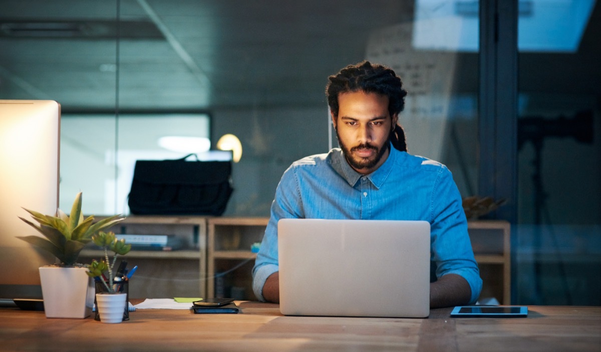 Cropped shot of a young designer working late on a laptop in an office