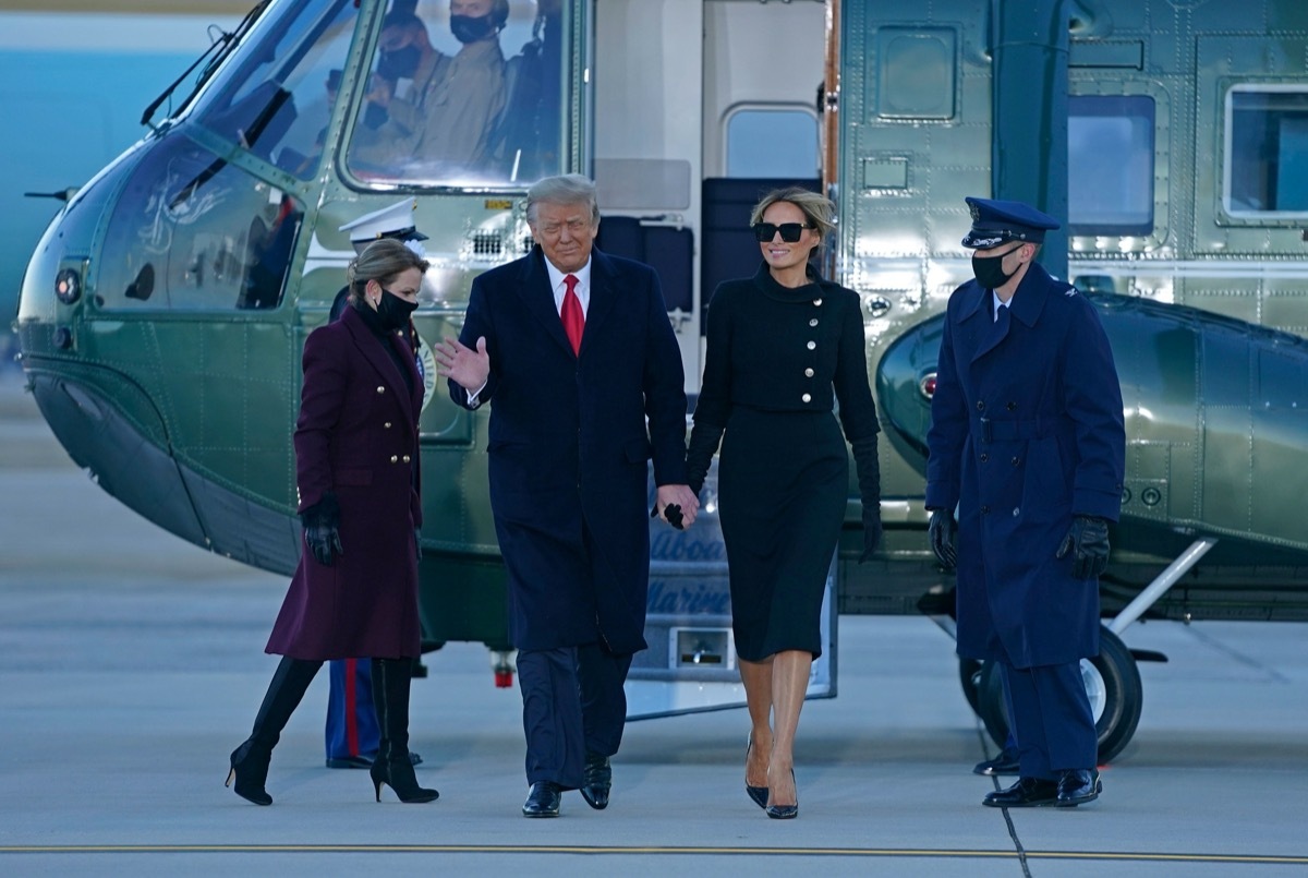 donald and melania trump walk past military members after disembarking marine one