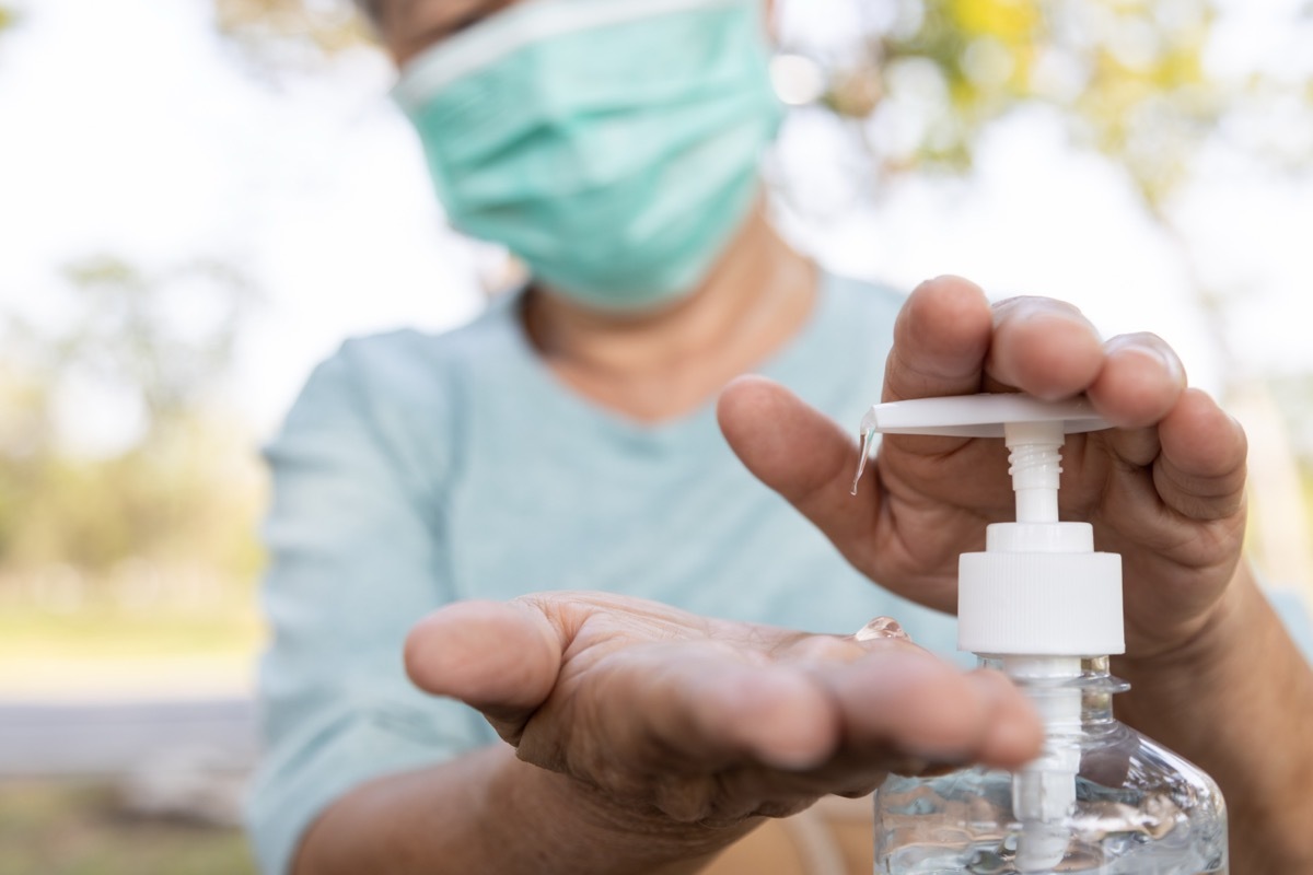 Masked Person Pumping Hand Sanitizer