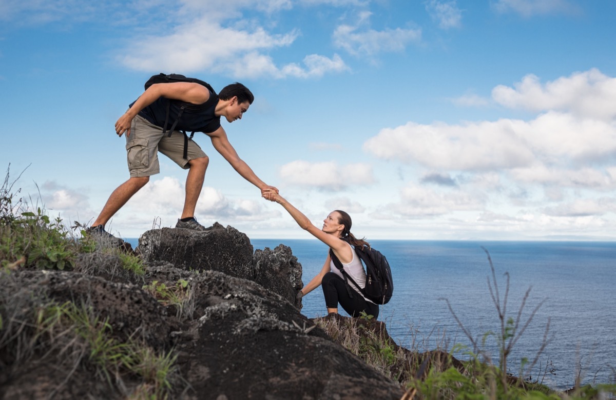 Man Helping Woman on Hike