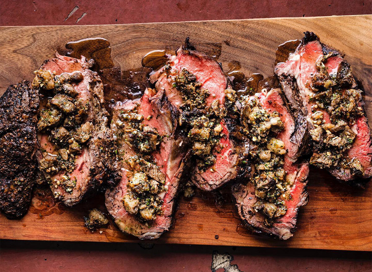 sliced steak topped with chopped mshrooms