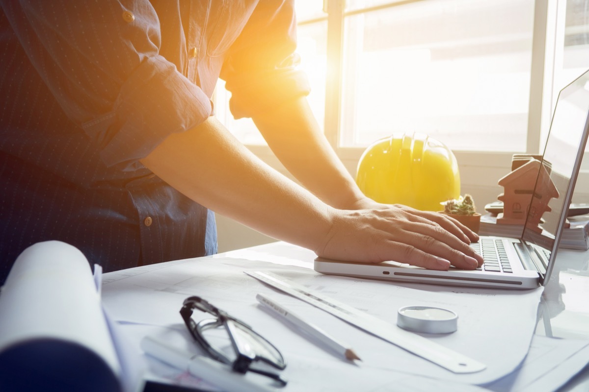 architect man working with laptop and blueprints,engineer inspection in workplace for architectural plan,sketching a construction project ,selective focus,Business concept vintage color