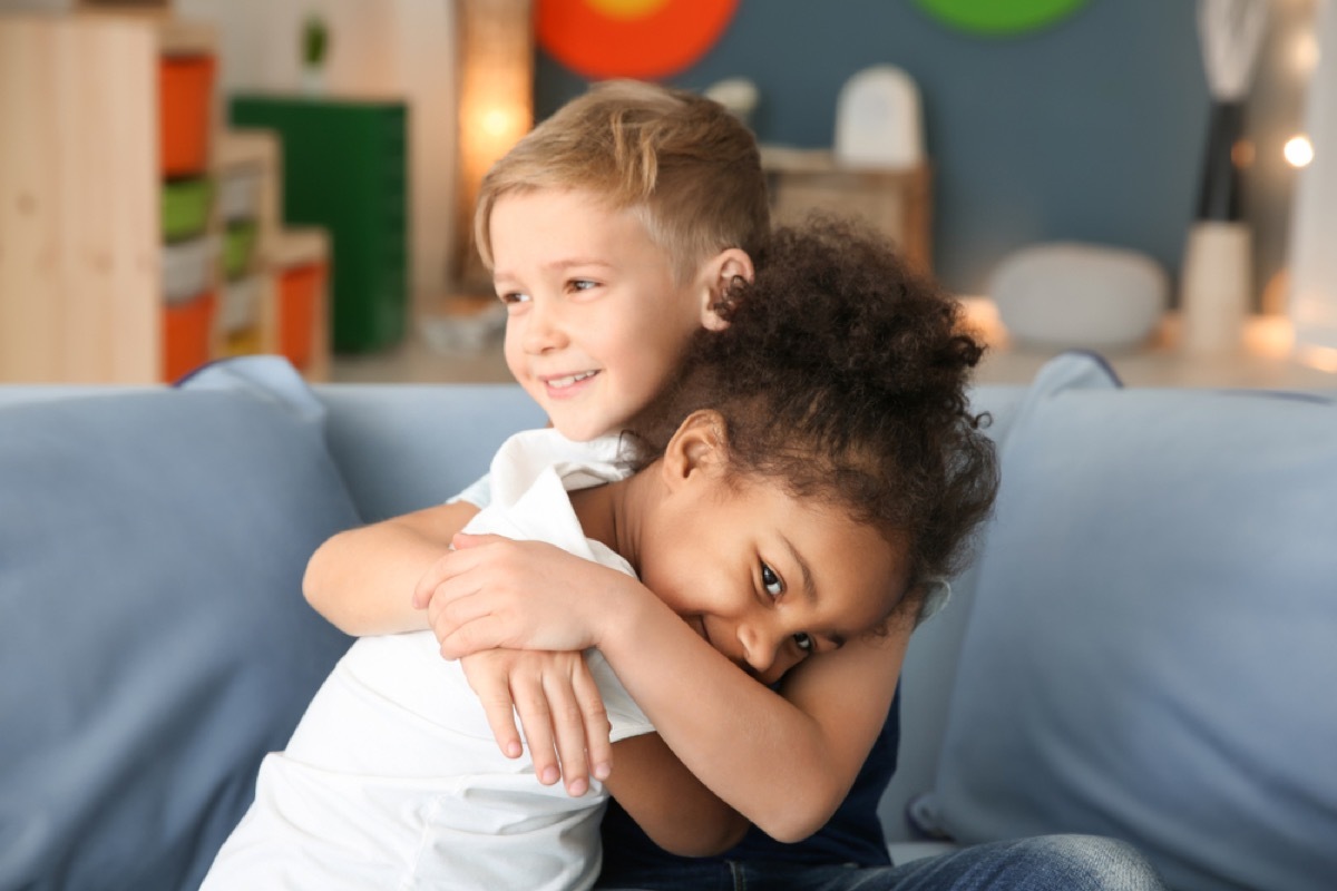 young girl and boy hugging on couch, skills parents should teach kids