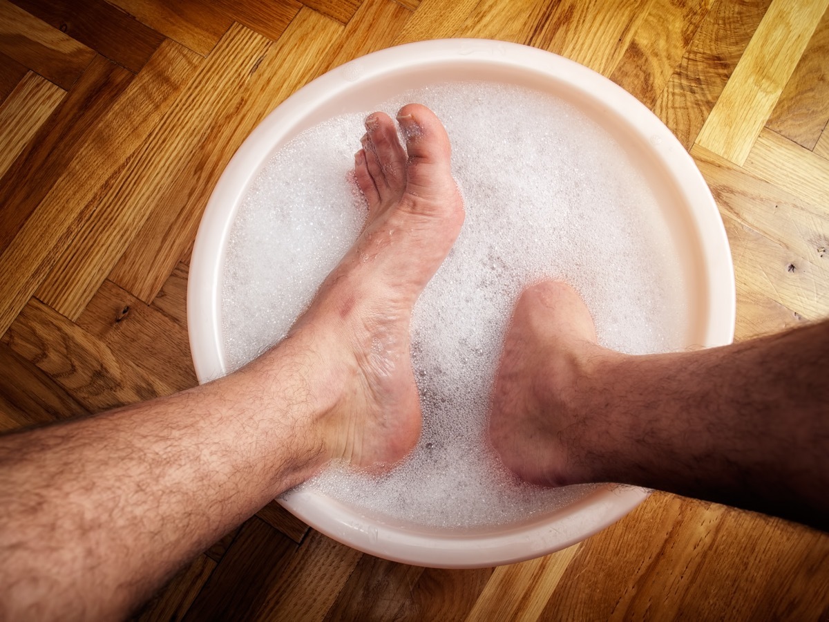 man soaking his feet in a washbowl