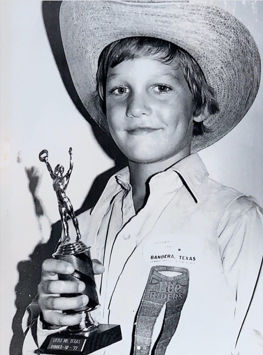 matthew mcconaughey as a child in a black and white photo wearing a cowboy hat and holding a trophy