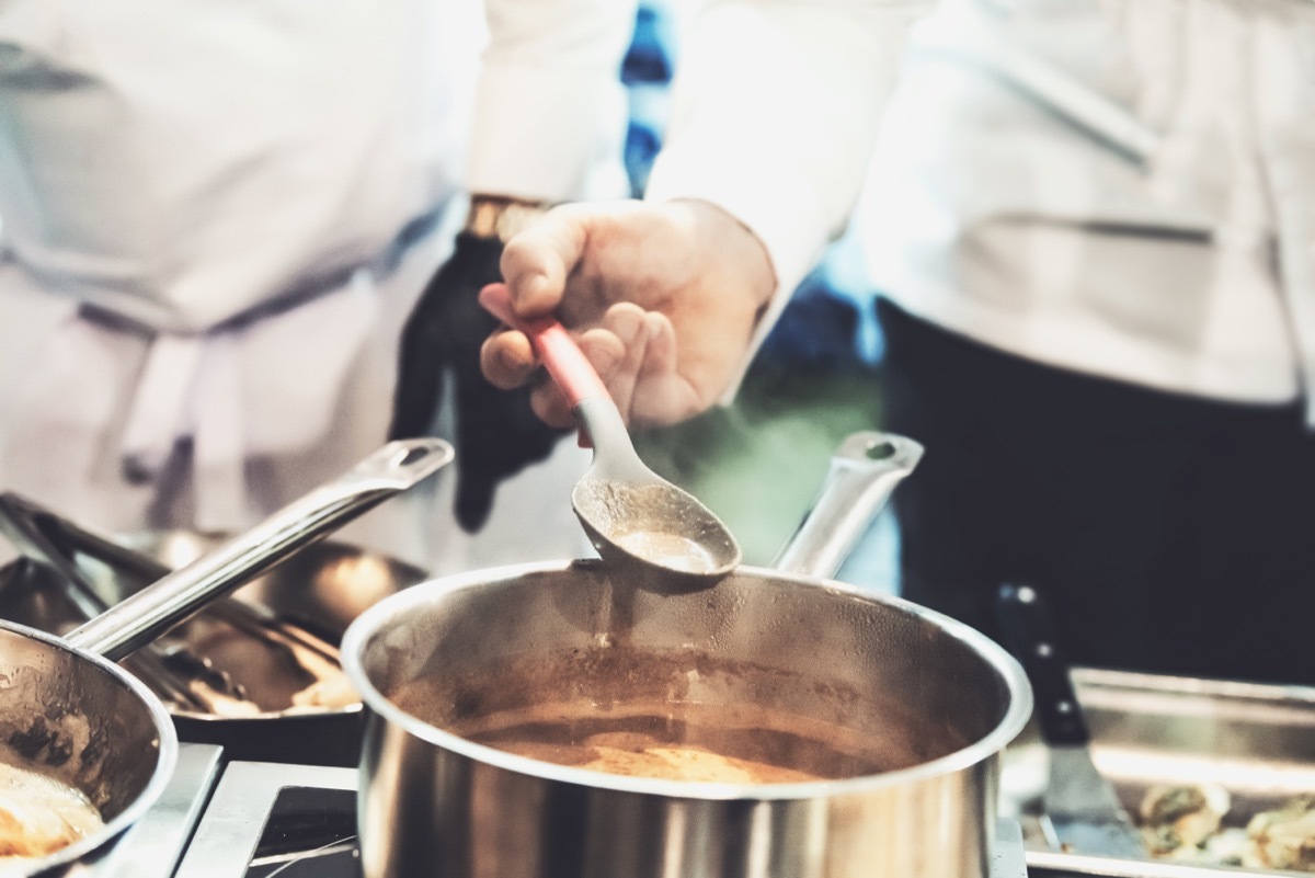 chefs making soup in silver pot